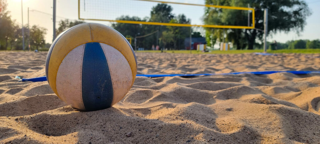 Beach volleyball court with a volleyball ball placed in the sand.